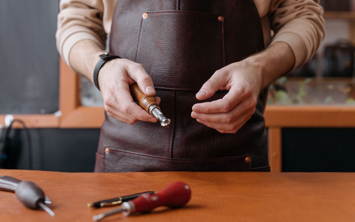 Un artisan façonne le cuir à la main avec un outil traditionnel