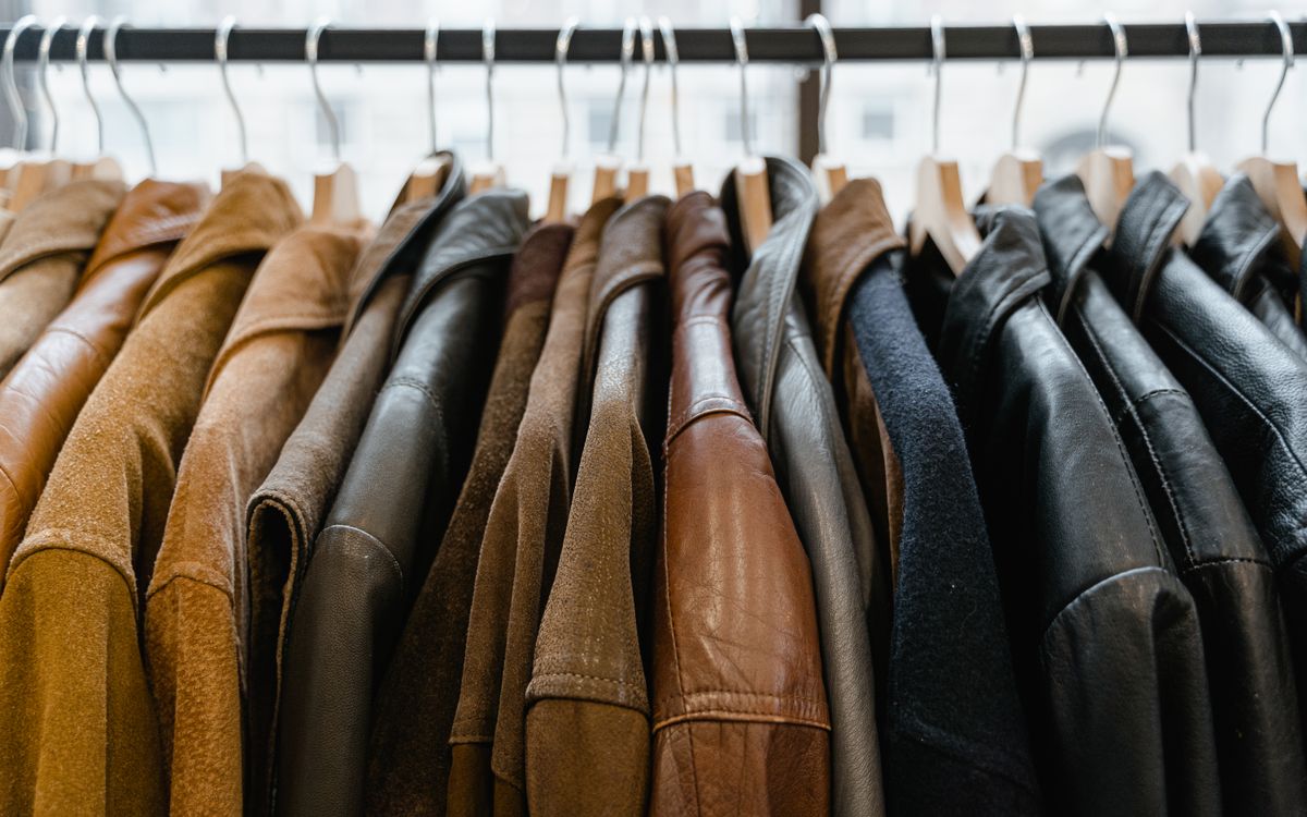 Des blousons en cuir alignés sur un portant en magasin