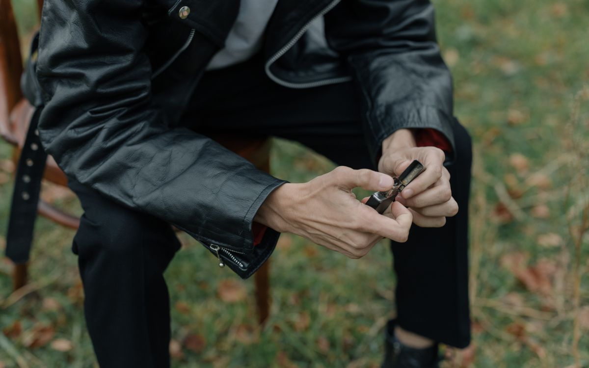Personne portant une veste en cuir assise en extérieur