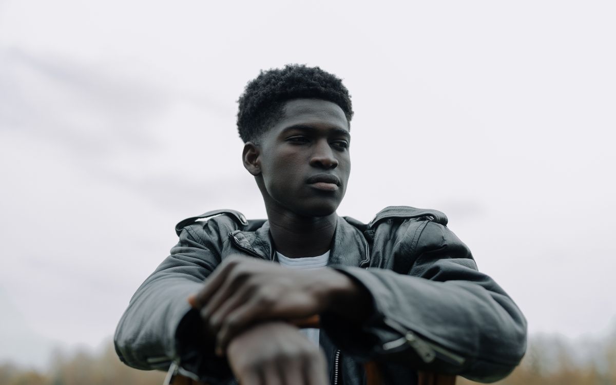 Buneri.fr | Pourquoi les PDG de la tech et les rock stars vivent en veste en cuir Portrait extérieur d'un jeune homme pensif en veste en cuir noire, respirant la confiance et le style