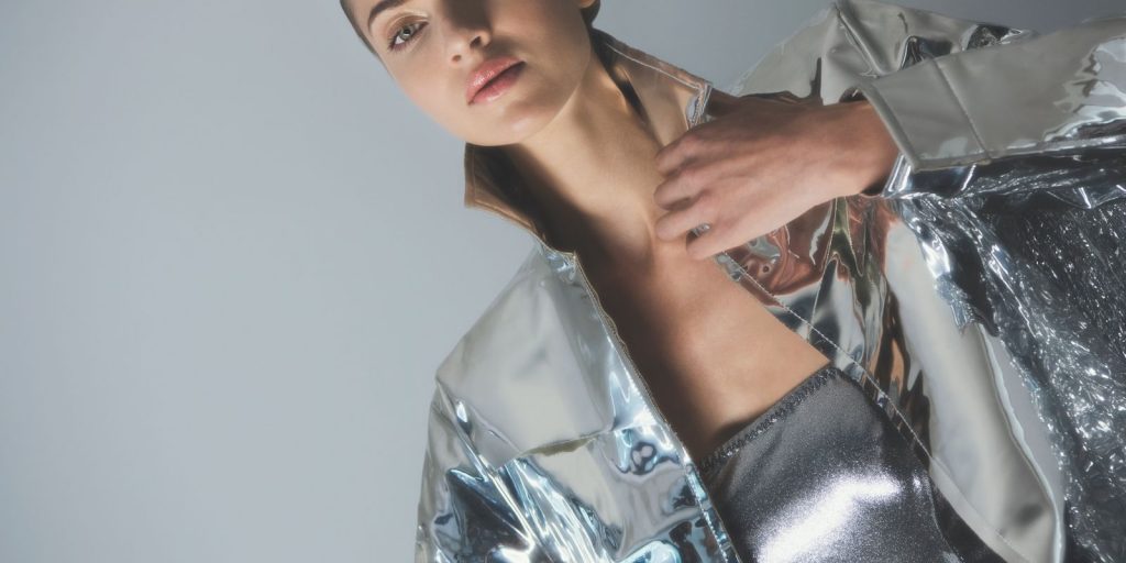 Mannequin dans un look argente et futuriste sous la lumiere du studio