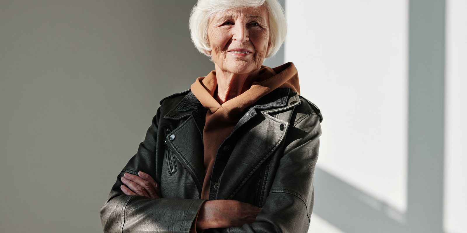 Une femme senior pleine d'assurance et de style dans un blouson en cuir noir avec un sourire chaleureux