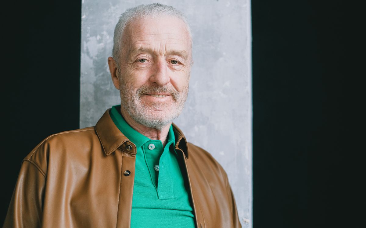 Portrait rapproché d'un homme senior souriant en blouson de cuir, en intérieur