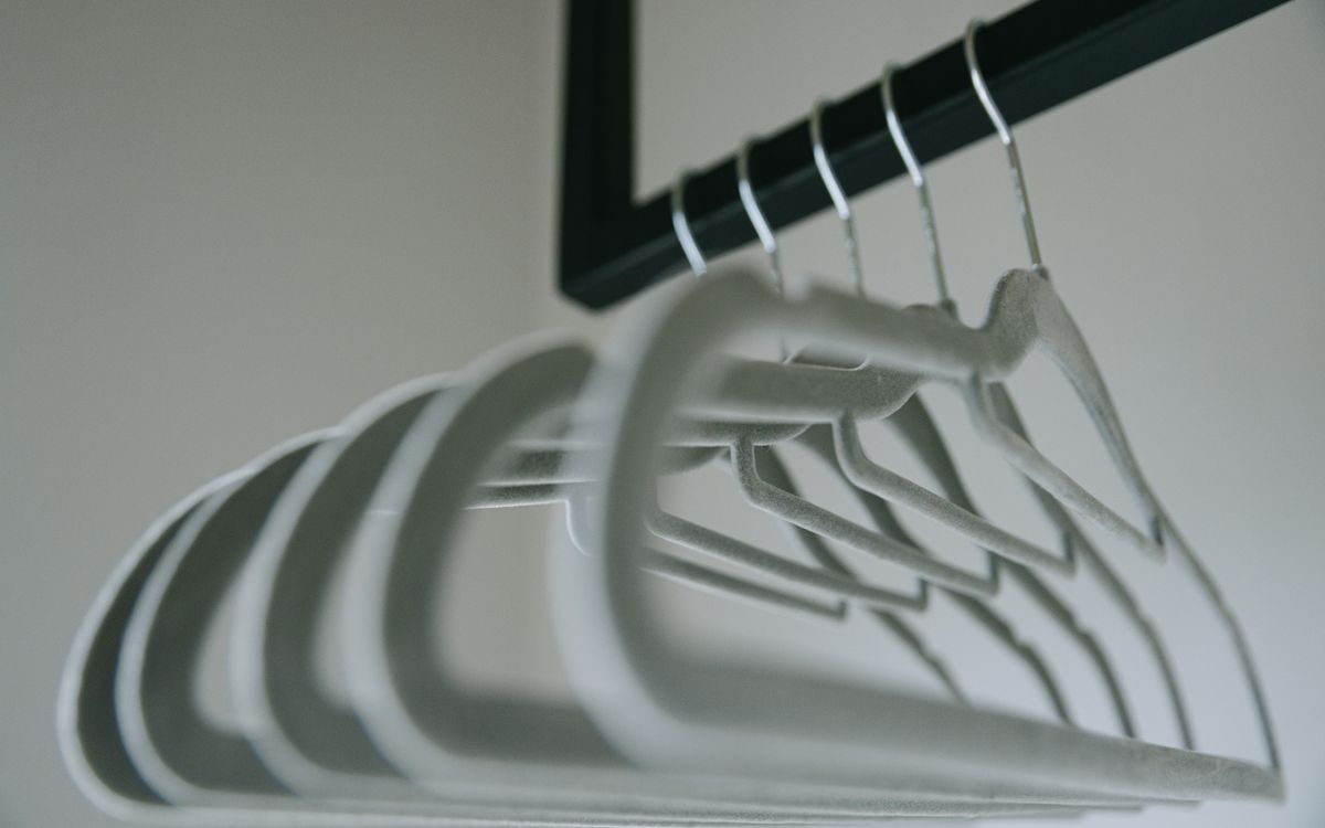 Cintres minimalistes en feutre alignés sur un portant