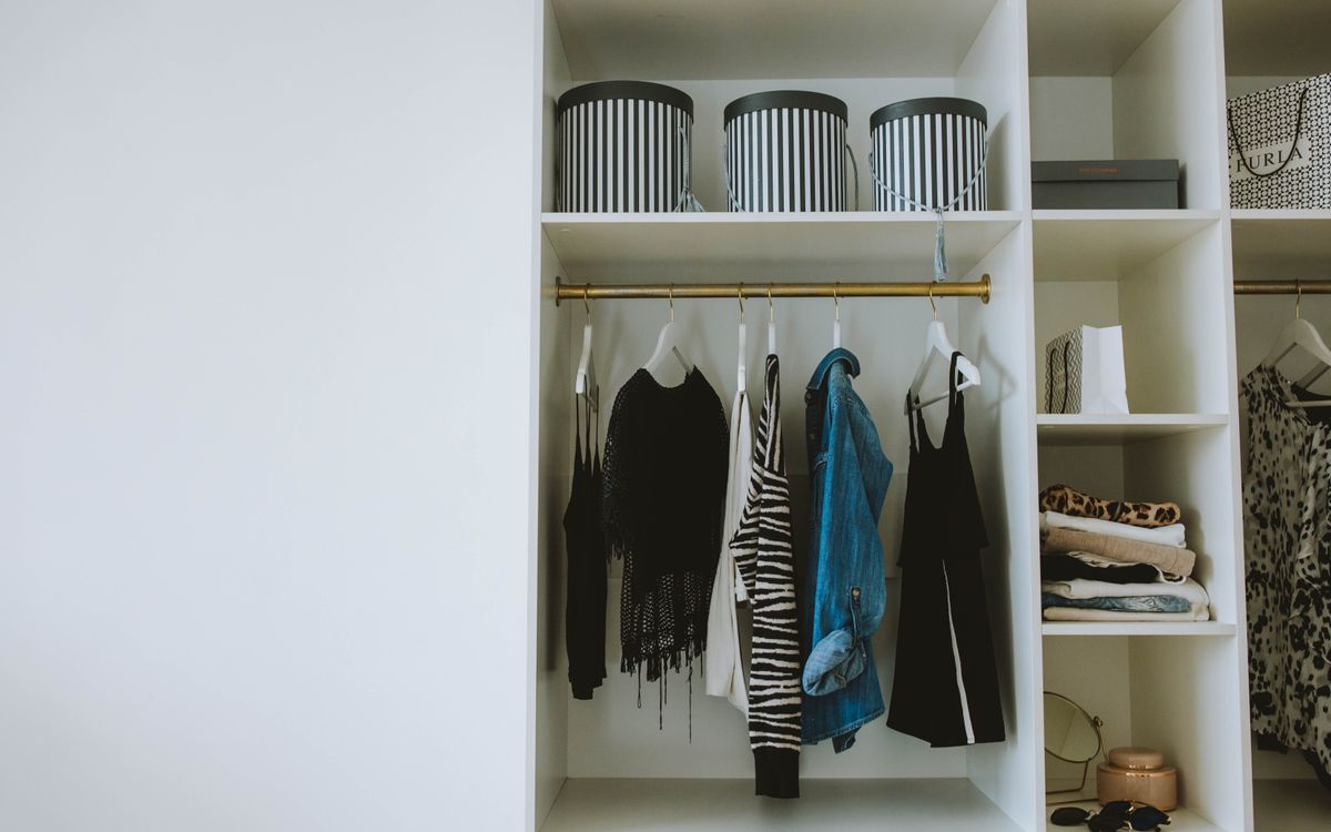 Dressing organisé avec vêtements pliés, cintres et boîtes de rangement