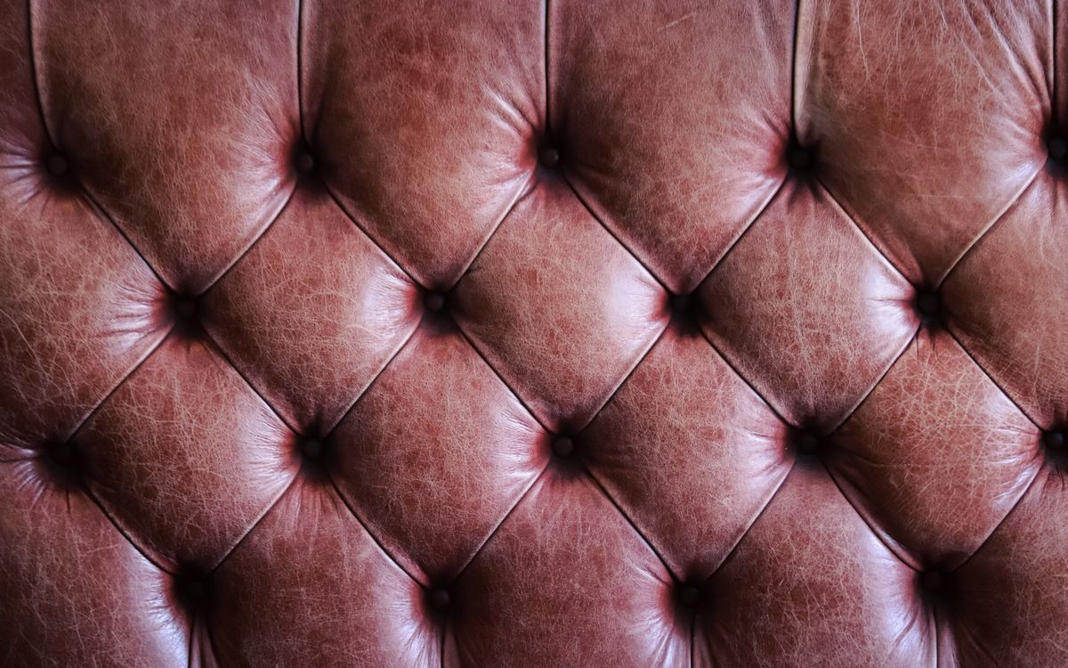Gros plan sur un cuir marron capitonné à la texture vintage