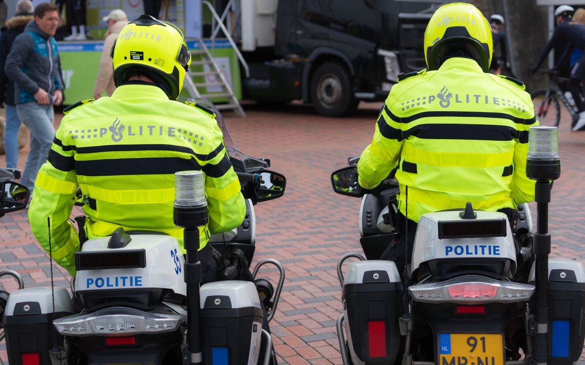 Deux officiers en uniforme clair patrouillant lors d'un événement public sur des motos