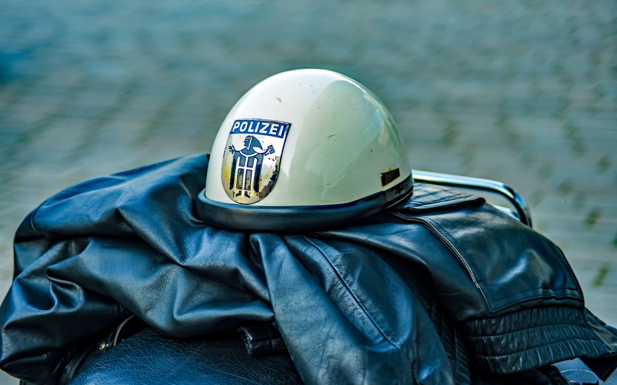 Casque de police rétro avec insigne posé sur un blouson en cuir en extérieur