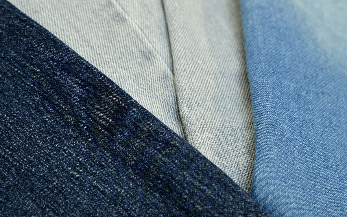 Gros plan sur un tissu denim bleu montrant sa texture et ses coutures
