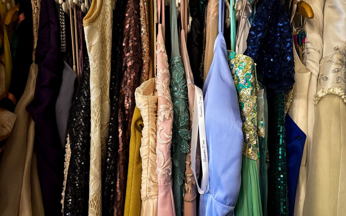 Un portant de vestes et vêtements vintage suspendus dans une boutique de seconde main