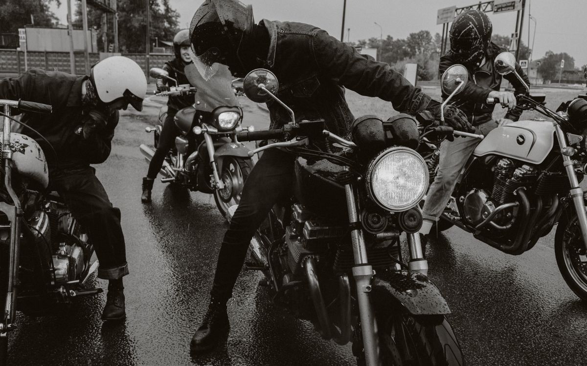 Un groupe de motards roule sur une route mouillée