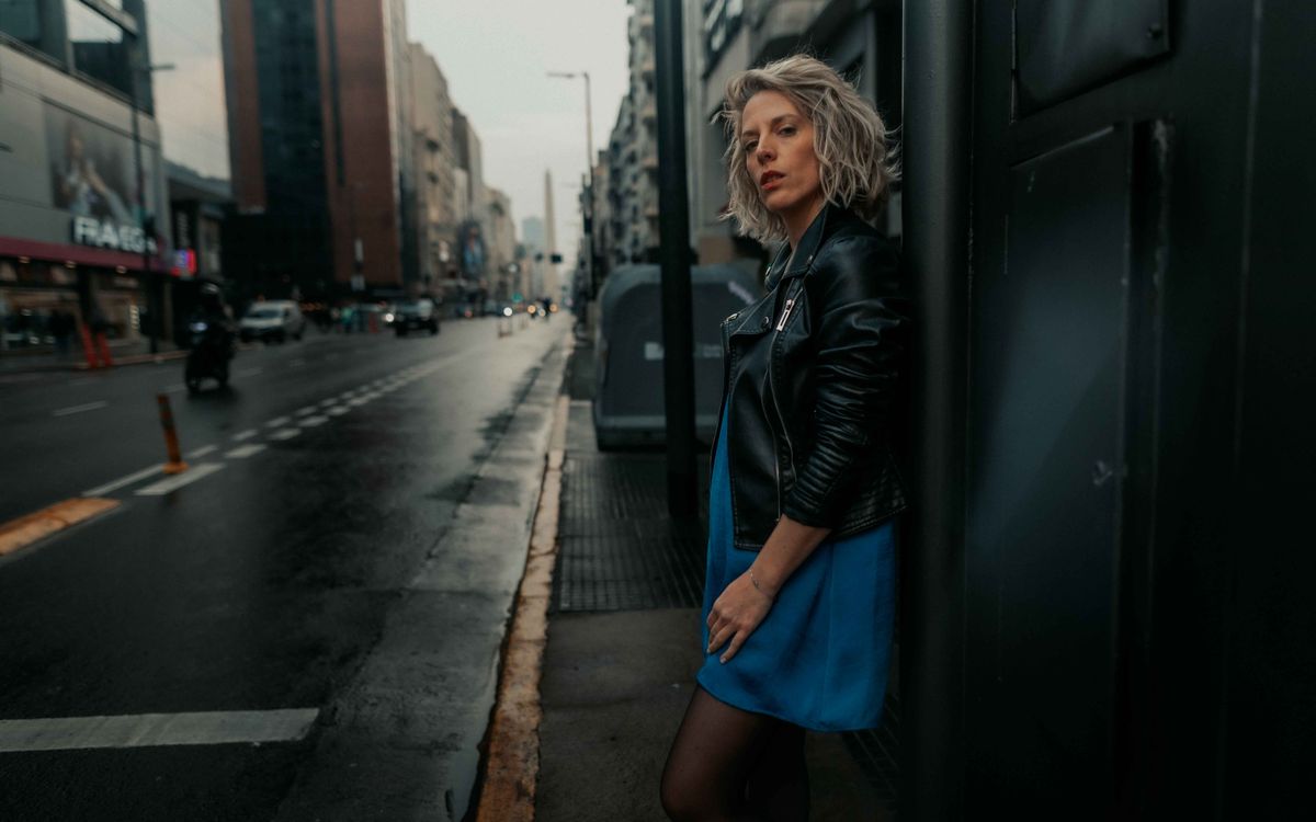 Femme élégante en veste de cuir dans une rue sous la pluie
