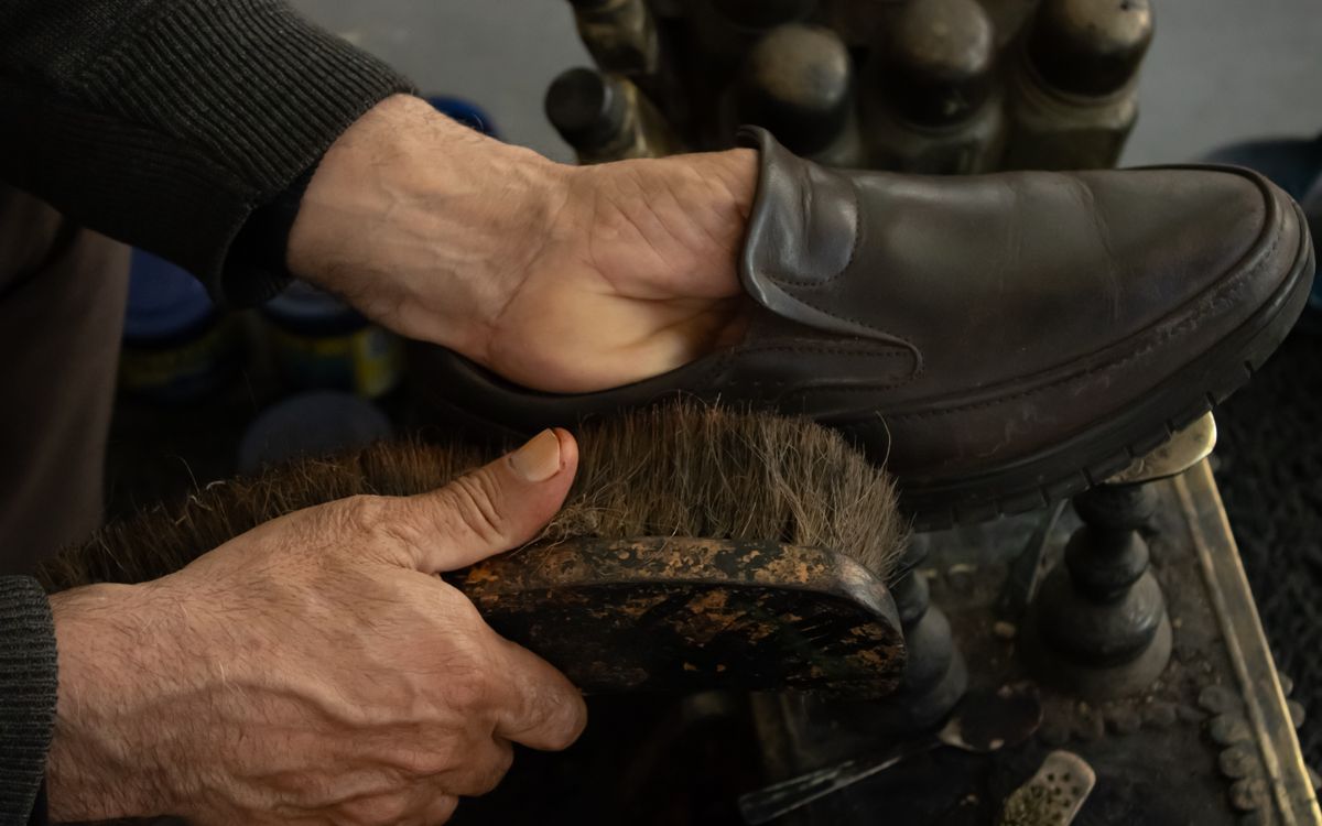 Brossage et lustrage soignés du cuir en atelier, une étape de la restauration complète