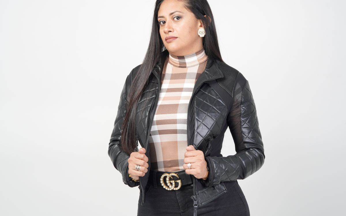 Une femme portant une veste en cuir noir, stylée avec assurance pour le temps frais