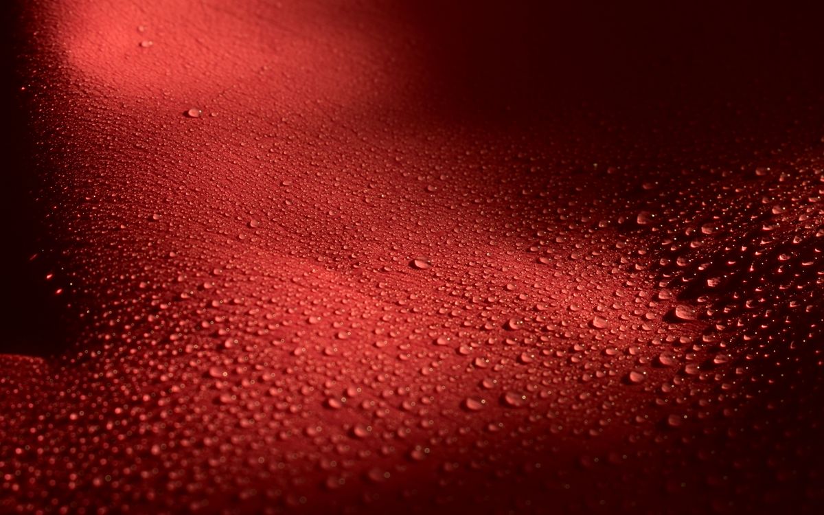 Des gouttes d'eau éparpillées sur une surface texturée qui accroche la lumière